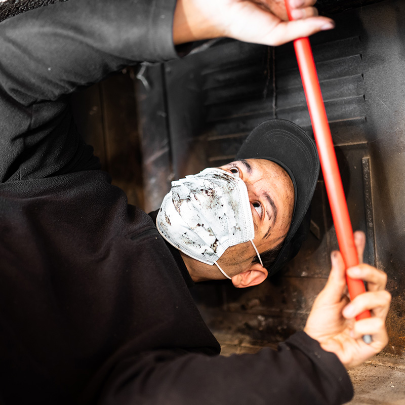 person cleaning chimney on roof during winter with blue sky above focusing on chimney maintenance and safety tips 3 methods for effective cleaning