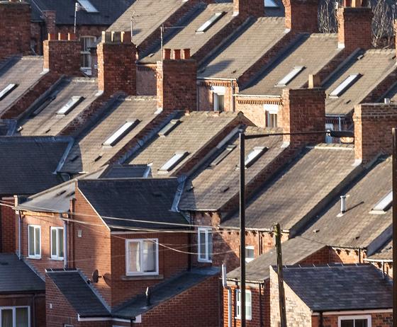 a black wood stove with a glass front displaying flames and stacked firewood on top located near a window showcasing a cozy atmosphere and modern interior design for two
